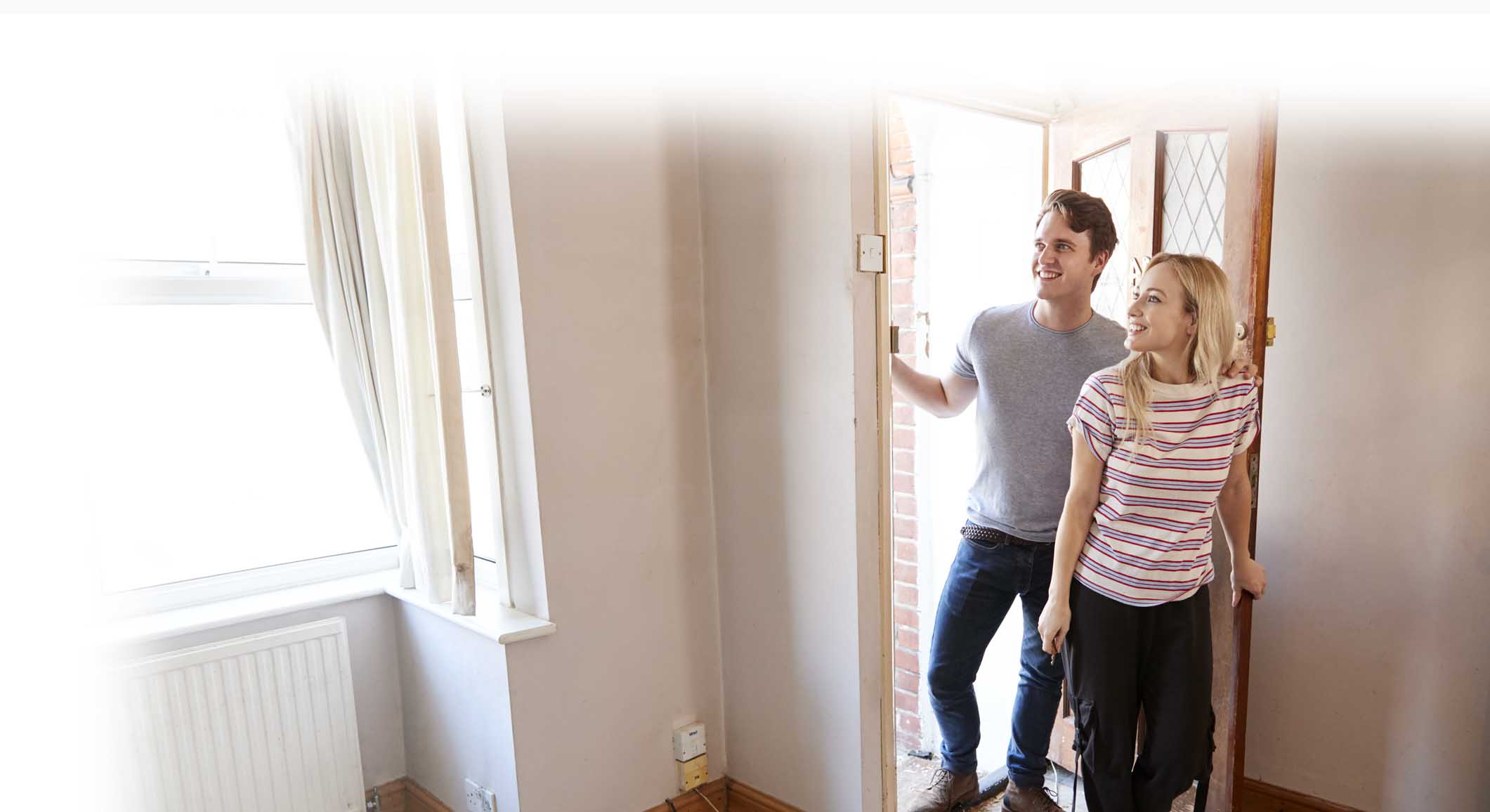 Young couple opening door to empty first home