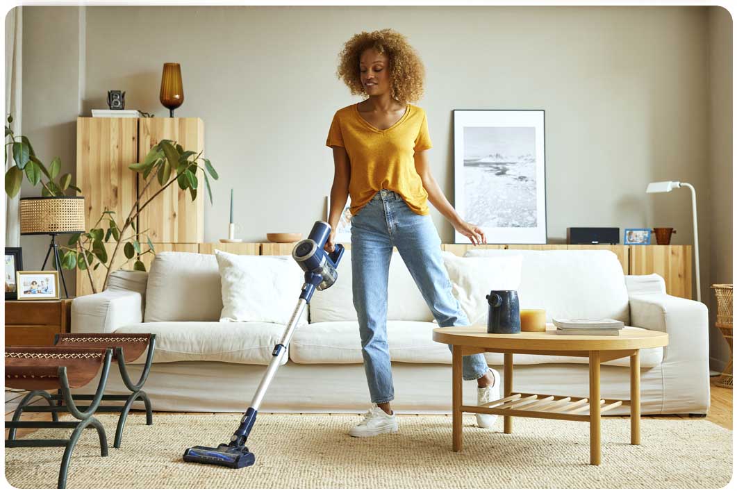 Woman in yellow top and jeans vacuuming
