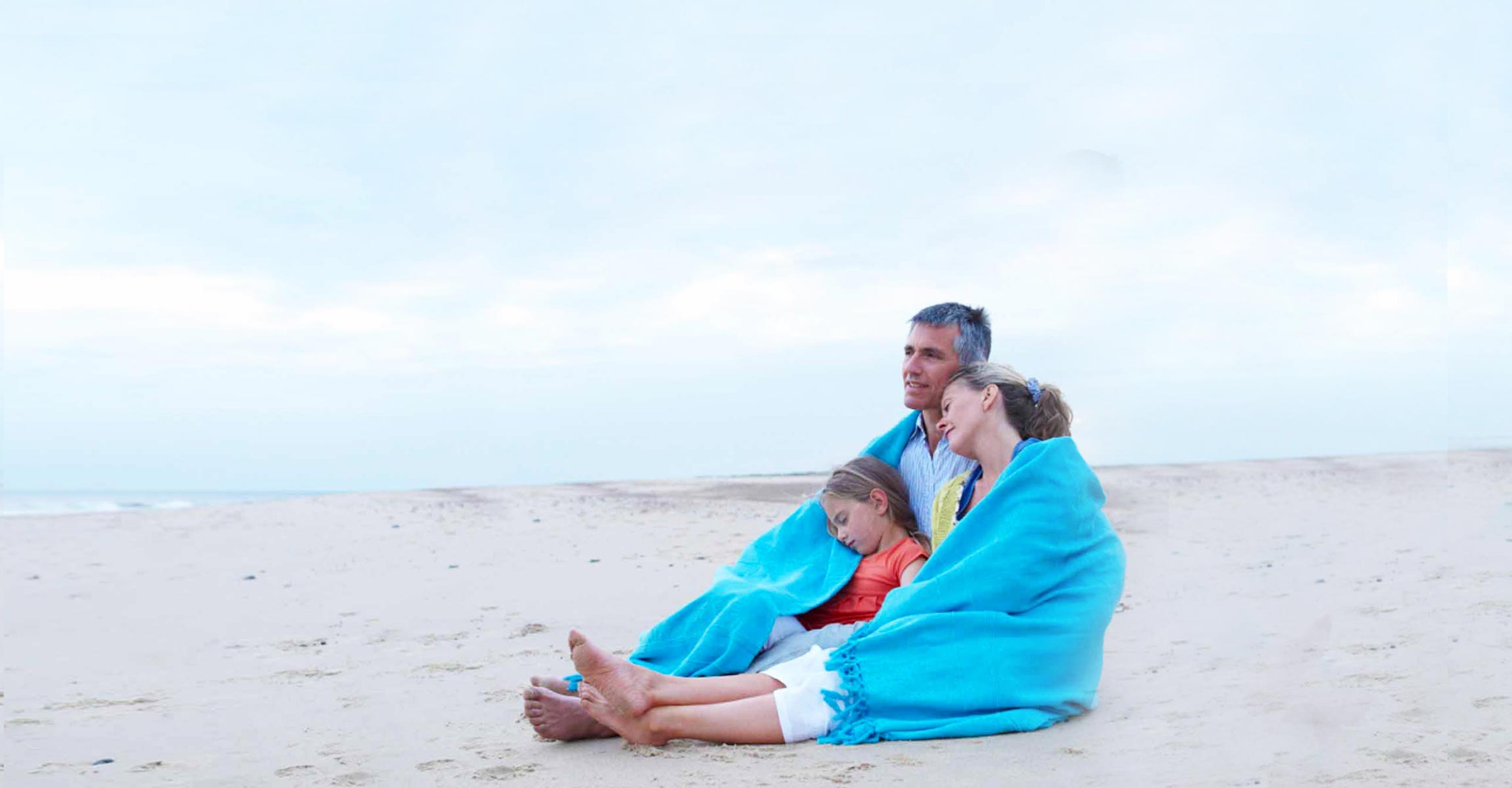 family on beach in blanket