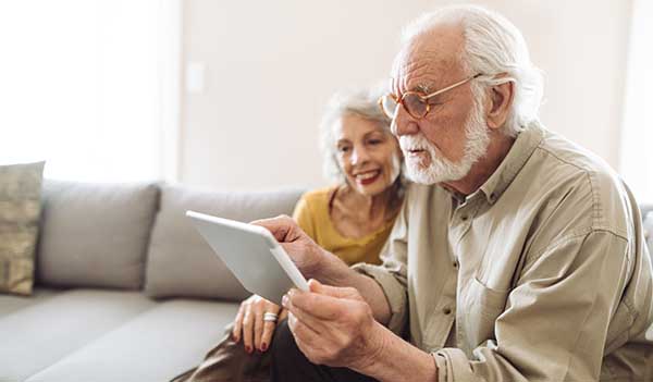older couple on sofa looking at tablet