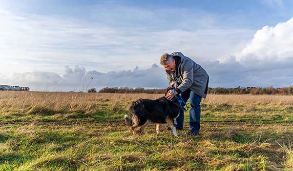 man in field with dog