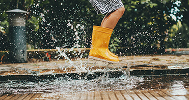 yellow boots splashing in puddle
