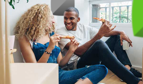 Couple celebrating move with pizza