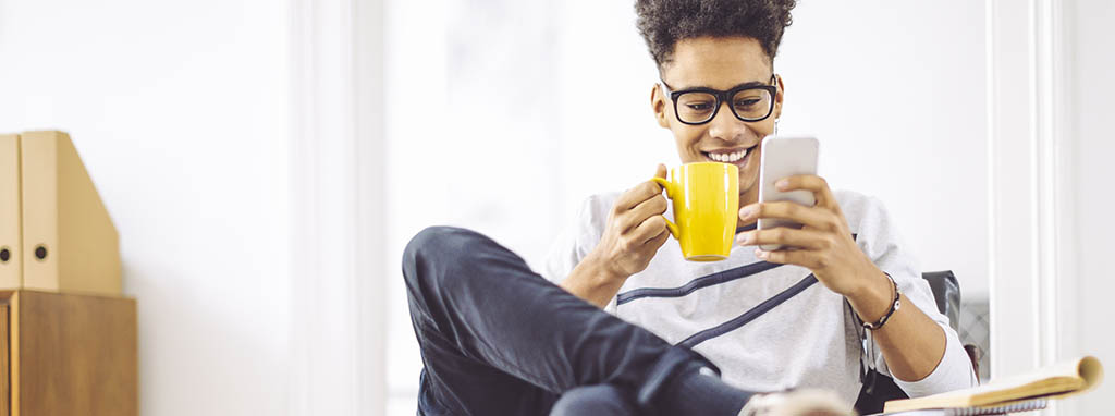 young man on phone with mug