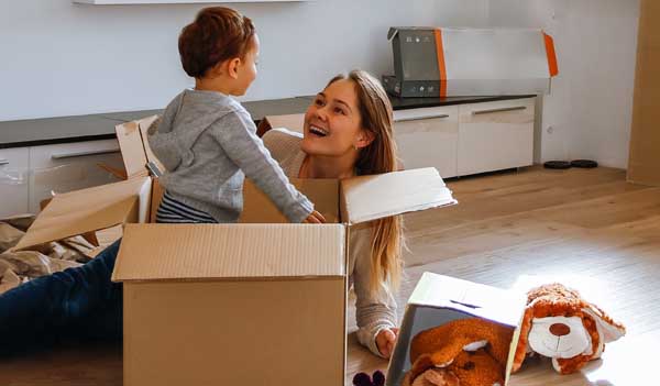 woman playing with child and moving box