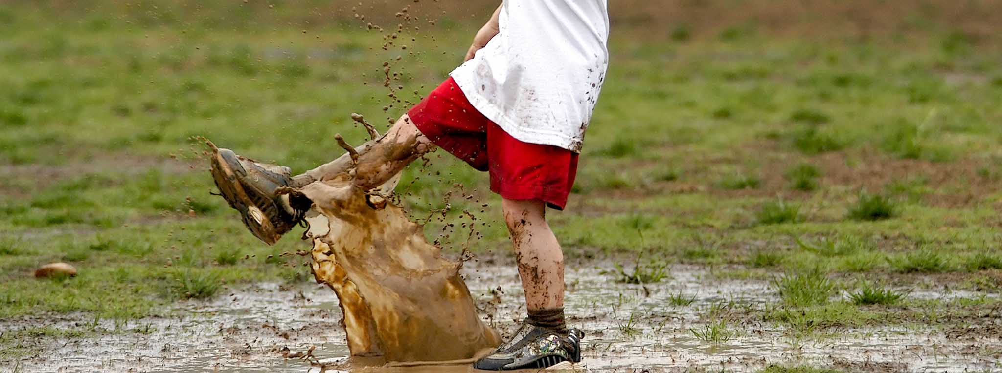 Child splashing in puddle