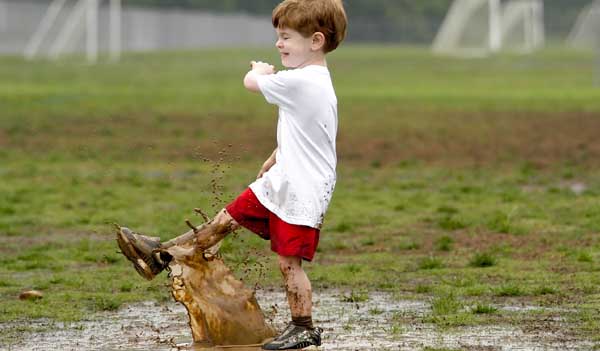 Boy splashing in puddle