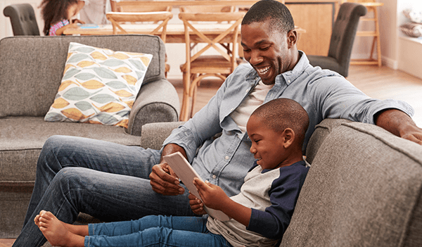 child sitting on the sofa with parent on phone