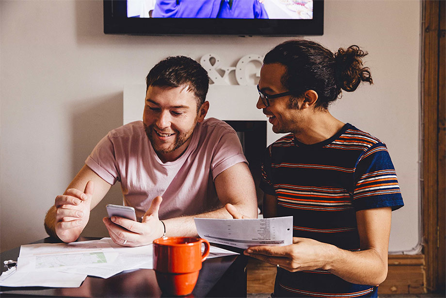 Smiling couple with phone and bank statement papers