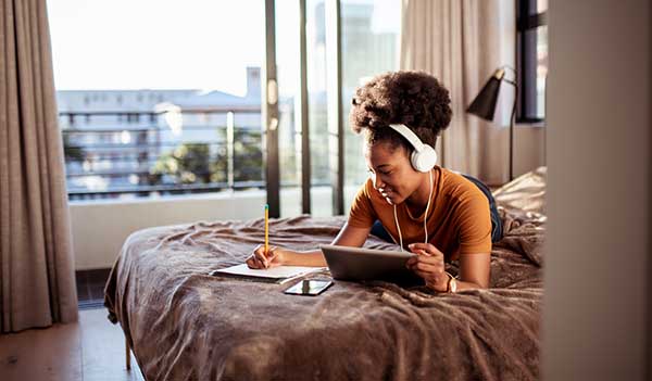 Woman writing and laying on bed