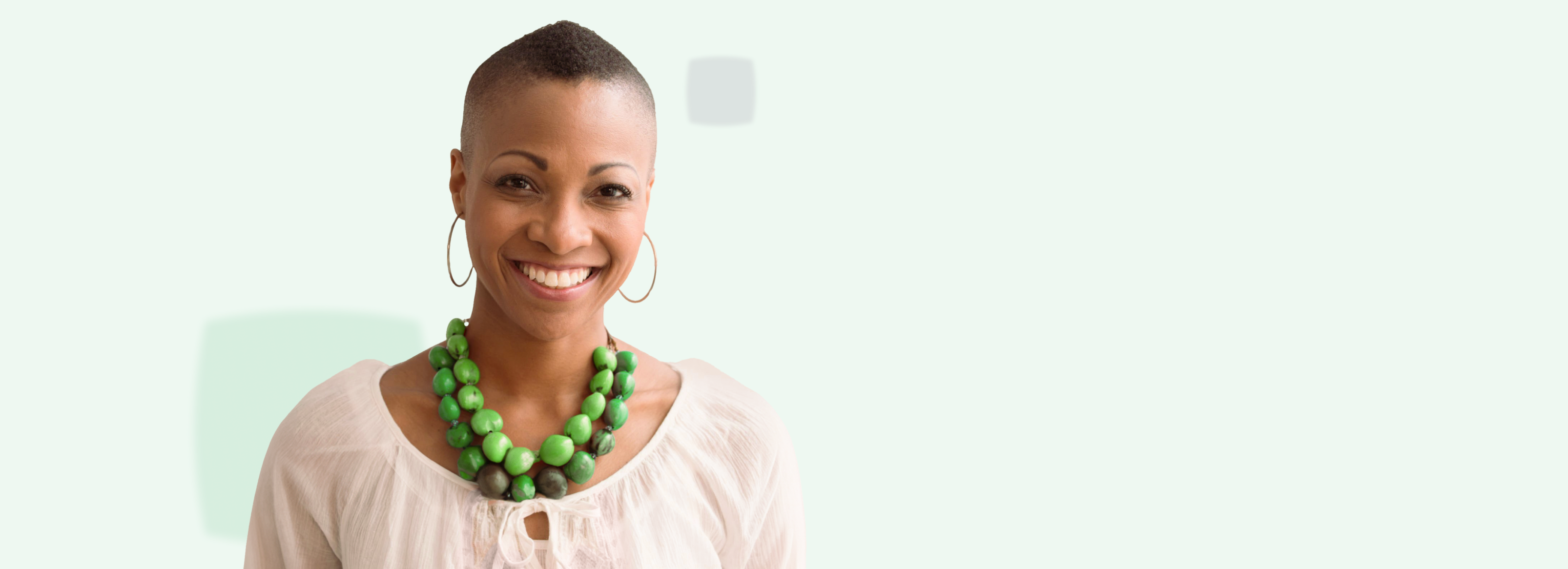 smiling woman with green necklace