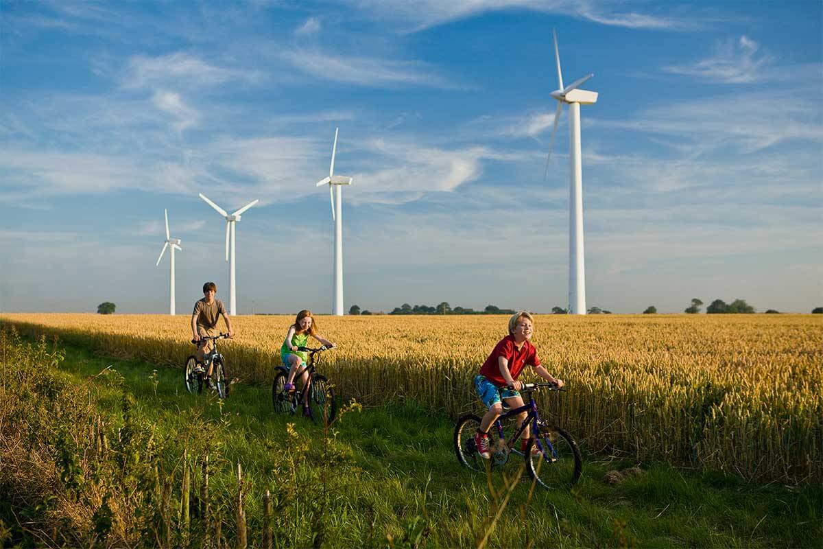 Children on bikes near wind turbines