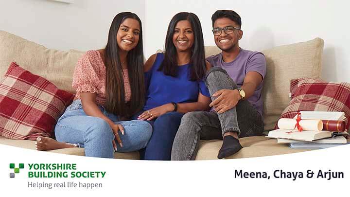 Meena and family smiling on sofa