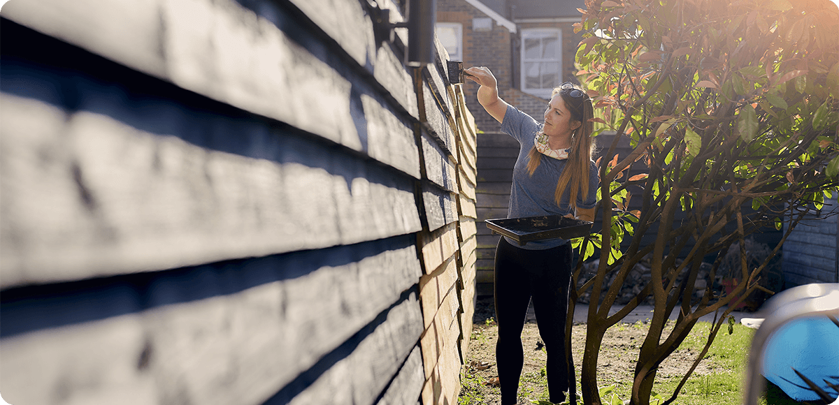 Woman painting fence