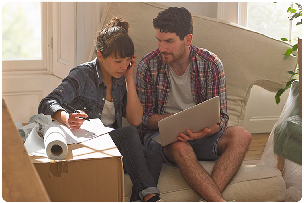 couple moving into new home looking at laptop