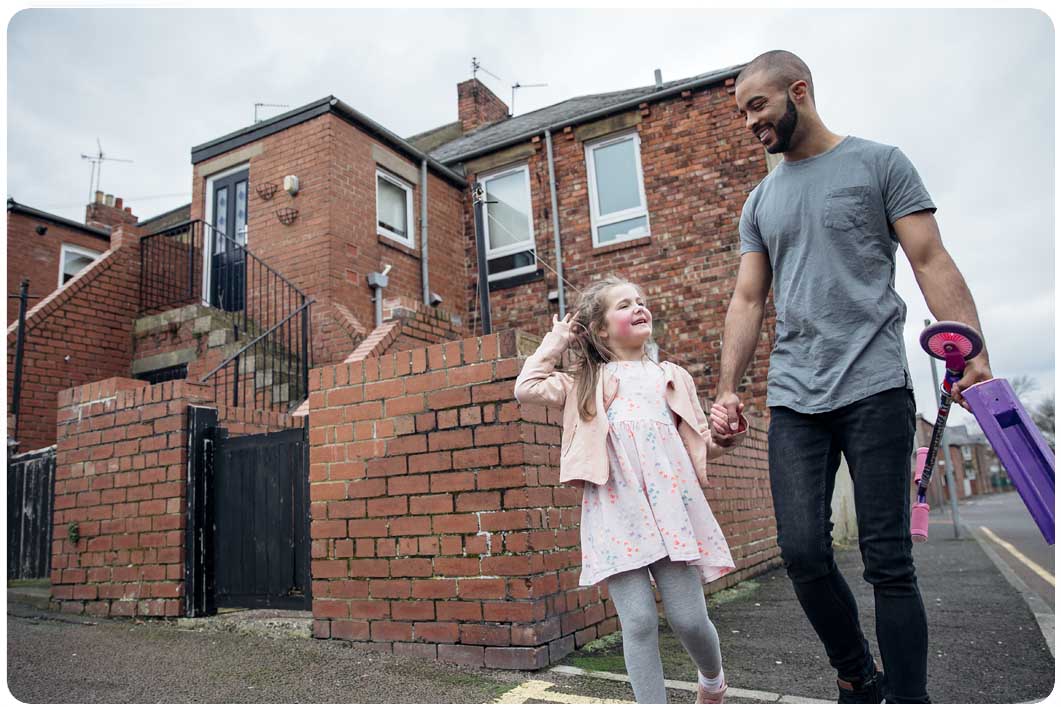 Man with daughter and scooter on street