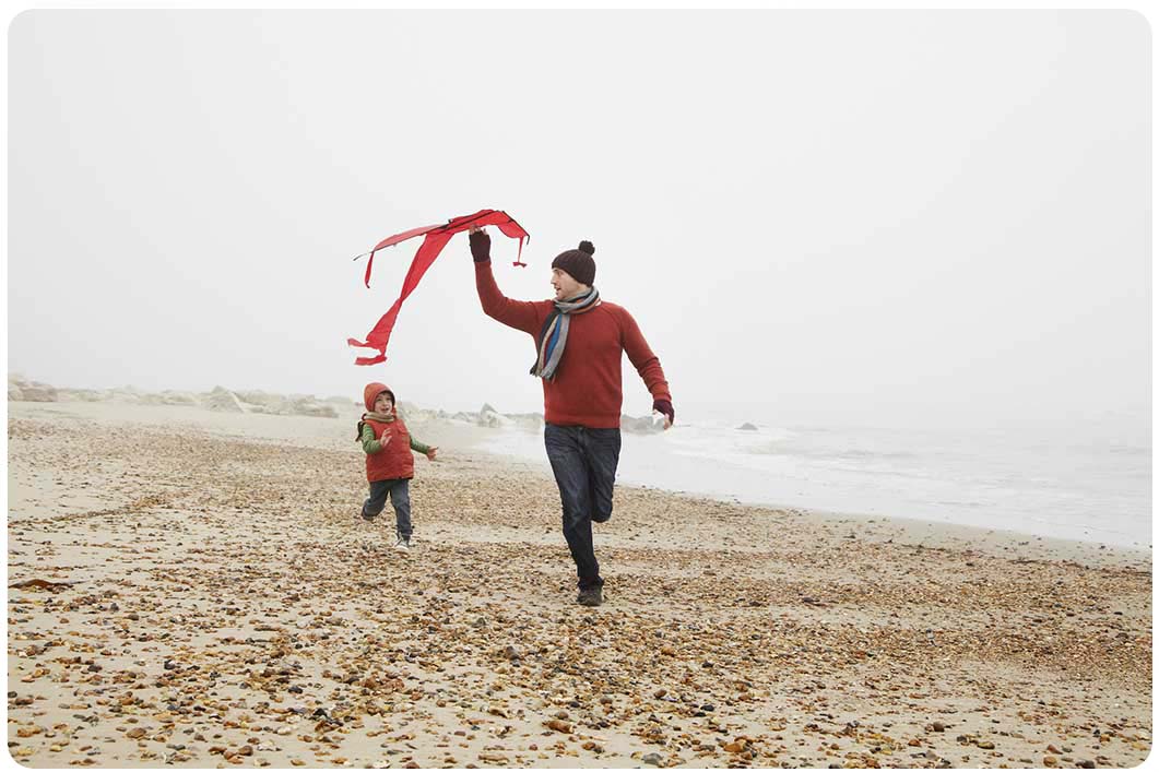 Man with child running on beach