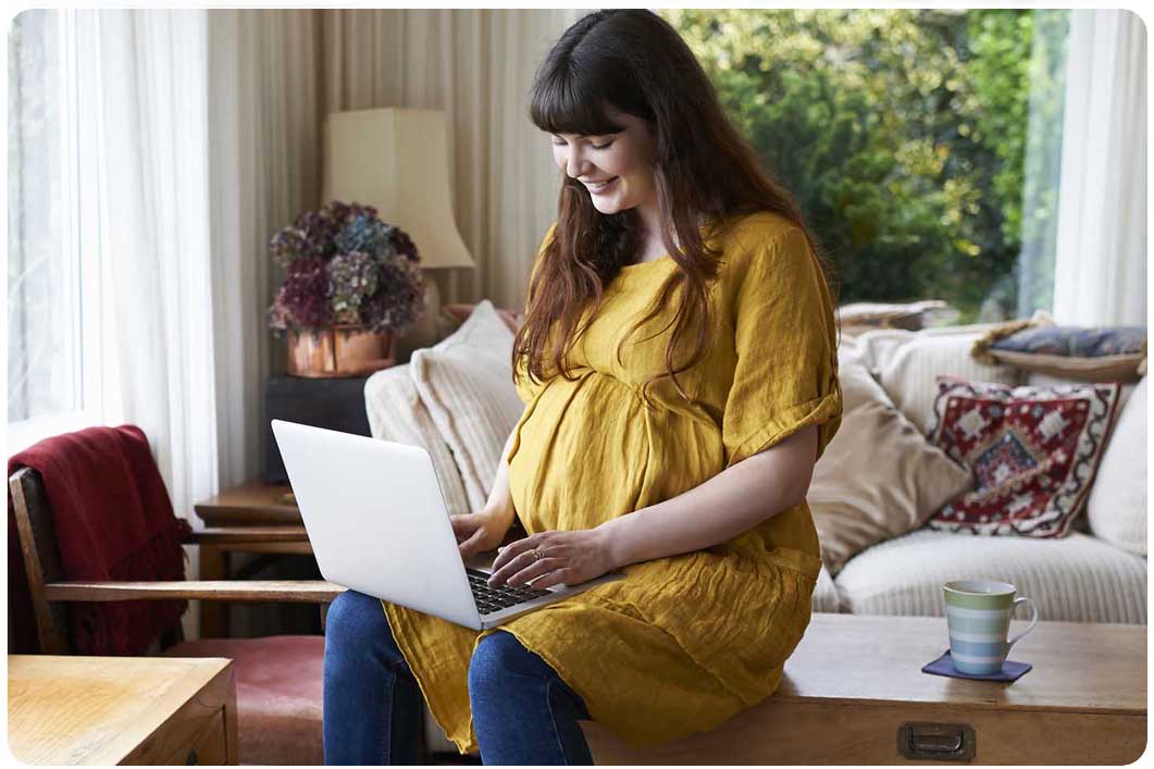 Pregnant person with laptop