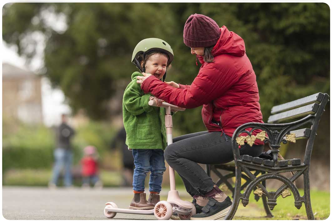 Toddler and scooter at park bench