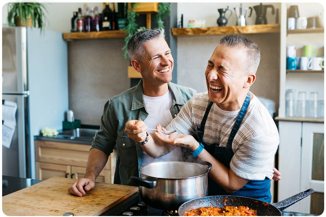 two men laughing and cooking