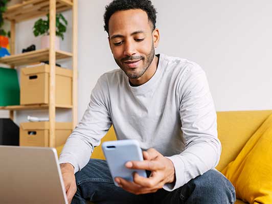 Man using mobile phone and laptop