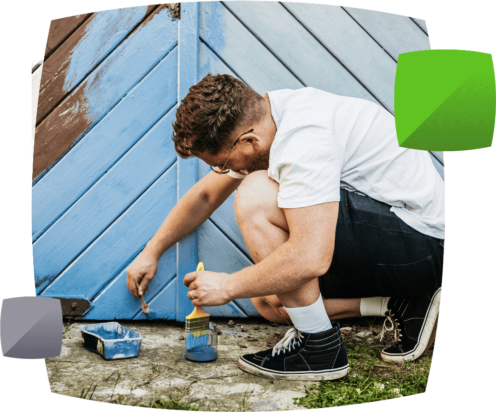 Young man painting fence