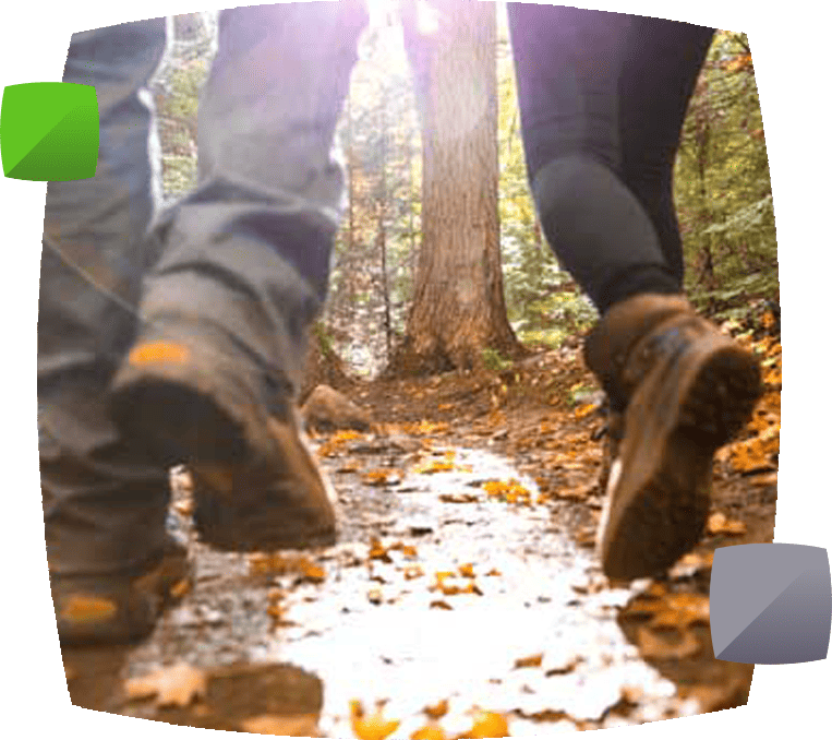 People's legs wearing boots walking in leaves